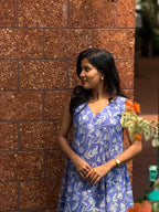 [PBC1007] Periwinkle Tulip Jaipur Hand-Block Cotton – three-quarter portrait against brick wall