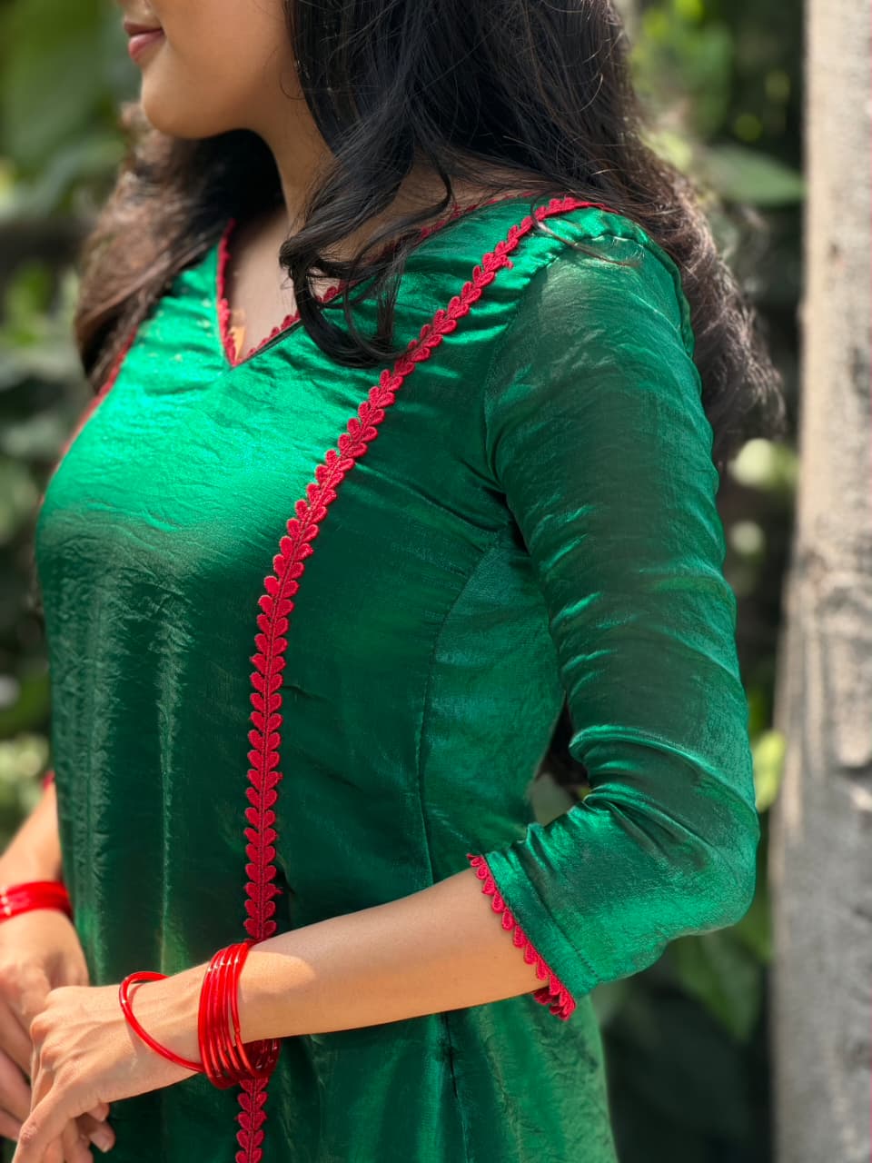 Close-up of [PBC1026] – emerald green Fendi Organza showing red heart-lace trim at neckline and front panel