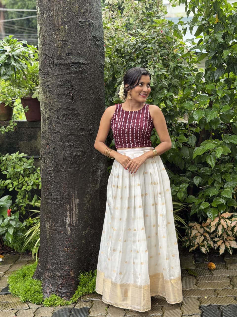 [PBC1071] Maroon bandhani blouse with ivory Kasavu skirt – three-quarter portrait view